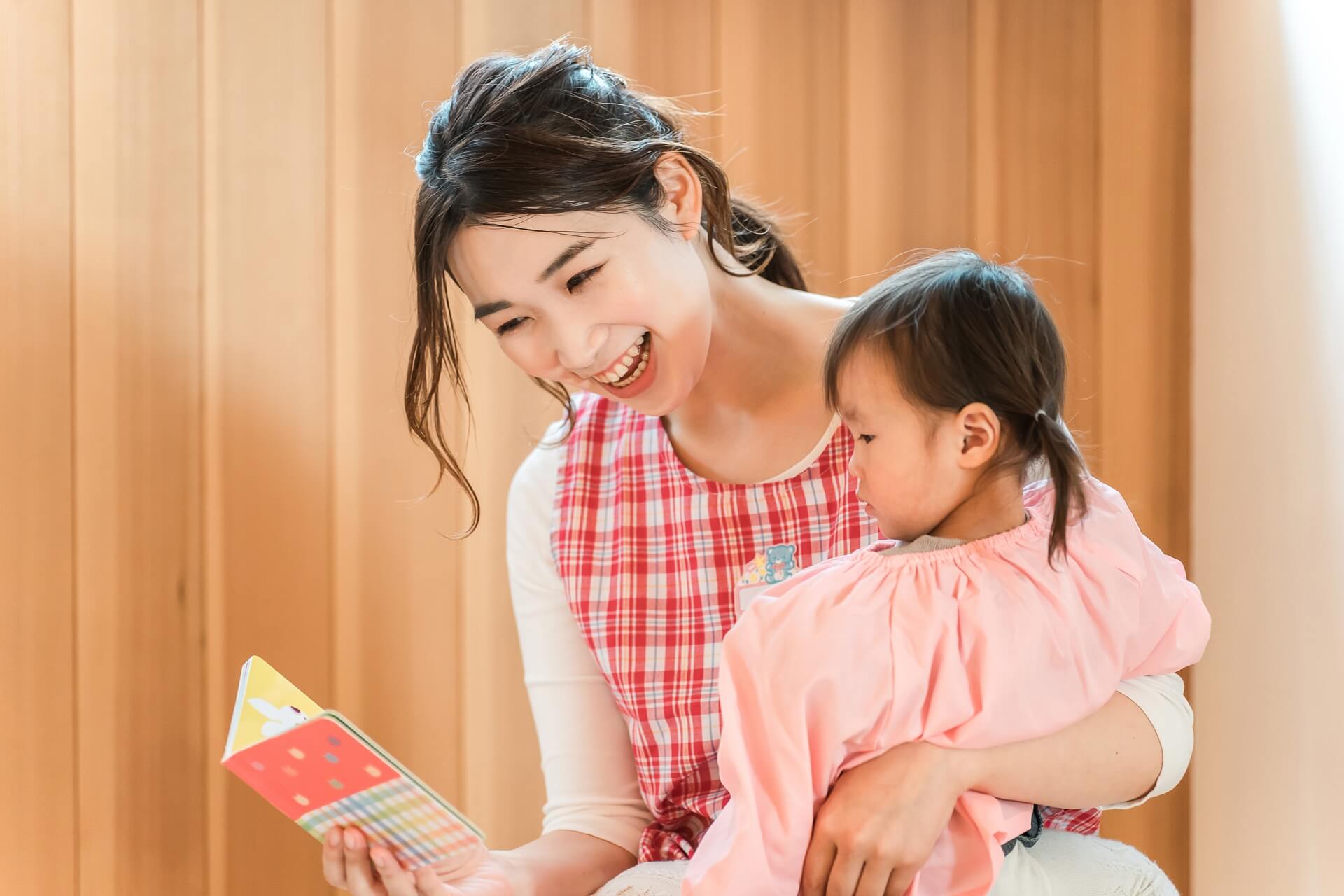 幼児を抱っこする保育士